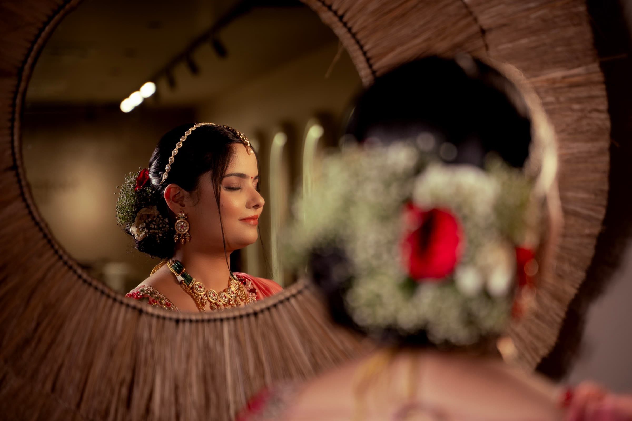 Close-up of a bride's floral hair accessory with her reflection in a mirror