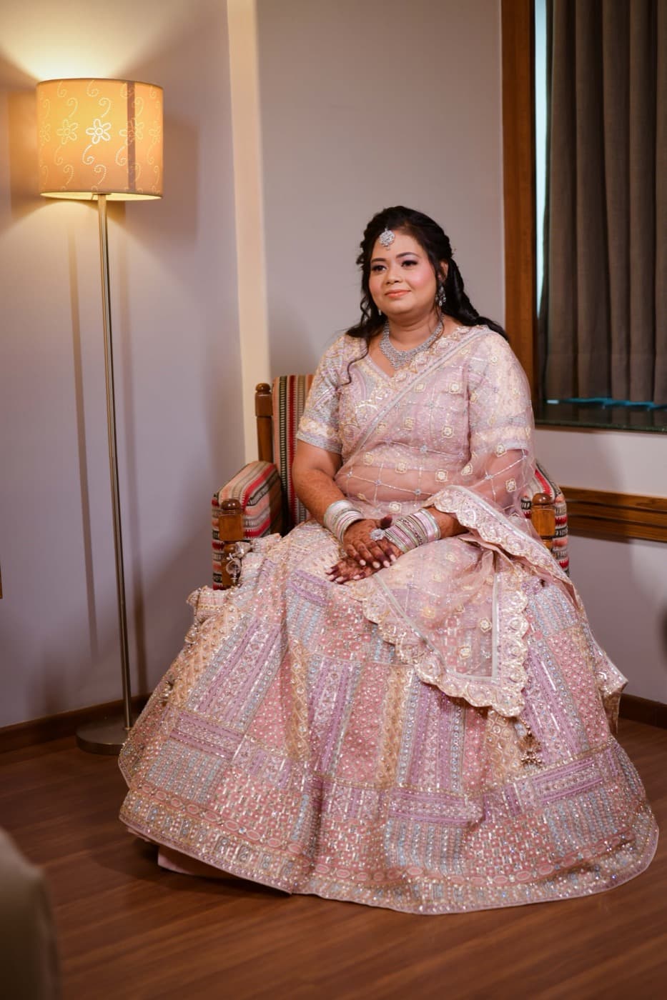 Bride seated in a chair beside a lamp for a styled bridal portrait