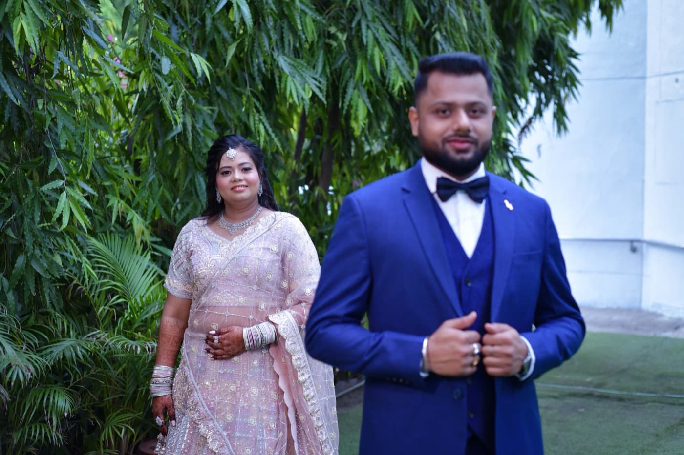 Groom walking with a family member through a garden setting