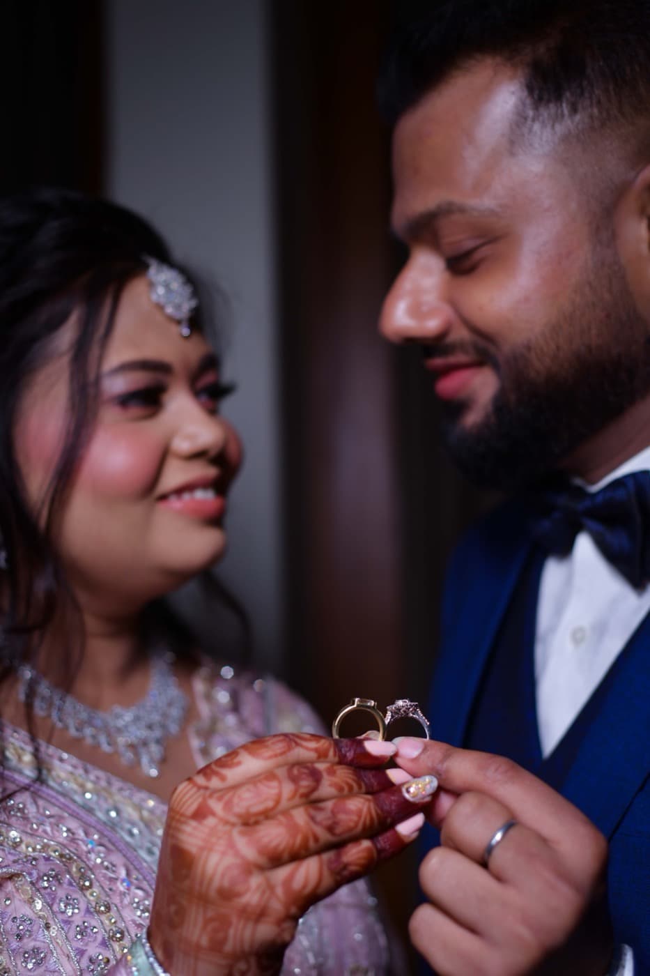 Close-up of two hands holding wedding rings